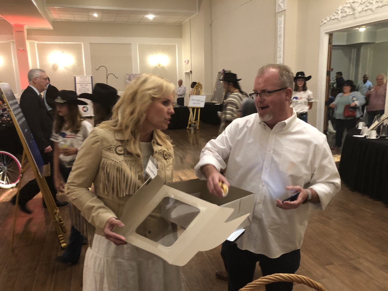 MaryBeth Ifft, of Grace Fellowship, offers Terry McGuire, of Sabbath Parkway Fellowship, some Bundt cake at Thursday’s Katy Christian Ministries Transforming Lives Gala. The gala is KCM’s largest fundraiser of the year and provides funding for its year-round operations and programs.